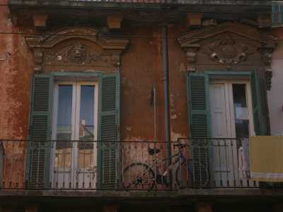 Foto 17. Unici invece sono i timpani che abbelliscono un balcone del palazzo adiacente, di cui uno caratterizzato dalla testa di un leone, che potrebbero far sembrare elegante questa casa, se non fosse per i modesti panni stesi e una bicicletta arrugginita che rivelano il carattere popolare dell�abitazione 